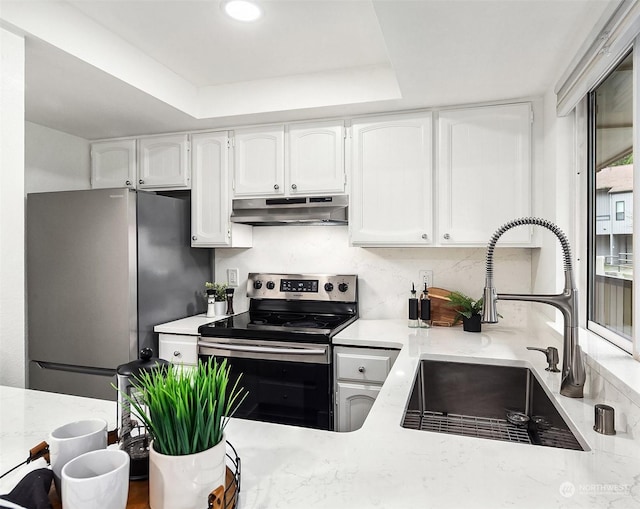 kitchen featuring a raised ceiling, white cabinetry, sink, and appliances with stainless steel finishes