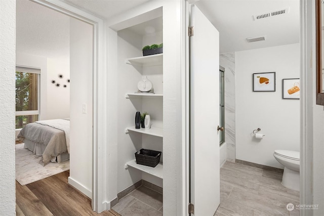 bathroom with wood-type flooring and toilet