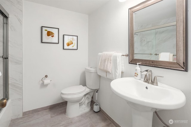 bathroom featuring sink, toilet, and walk in shower