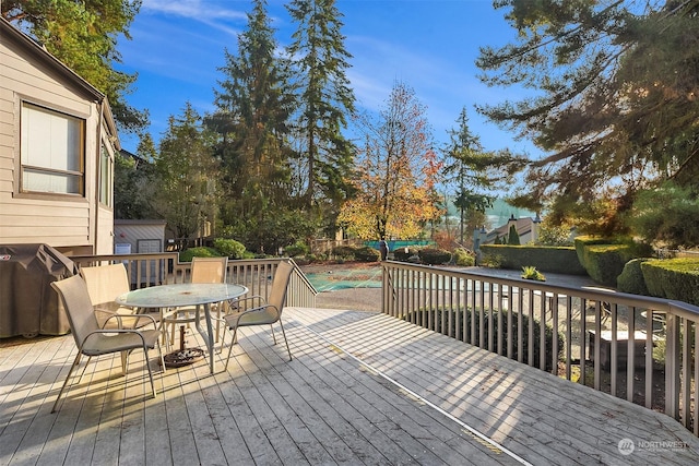 deck with area for grilling and a swimming pool