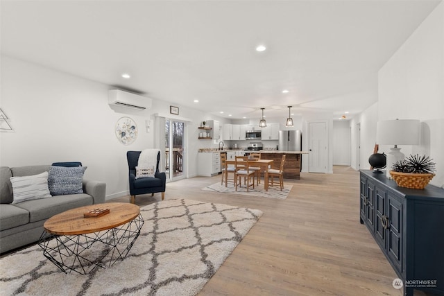 living room featuring light wood-style floors, an AC wall unit, and recessed lighting