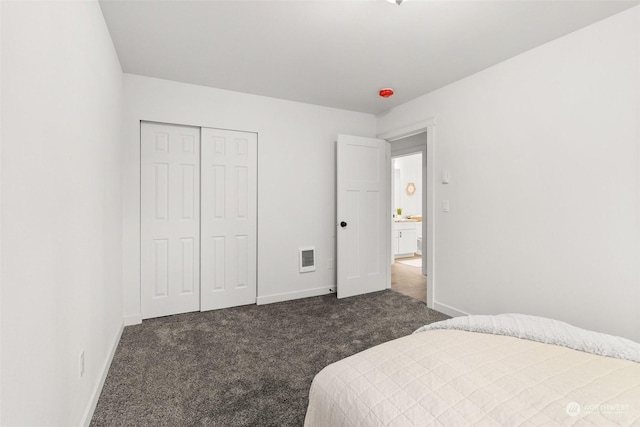 bedroom with dark carpet and a closet