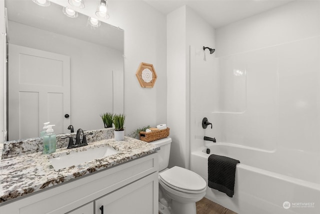 bathroom featuring tub / shower combination, vanity, and toilet