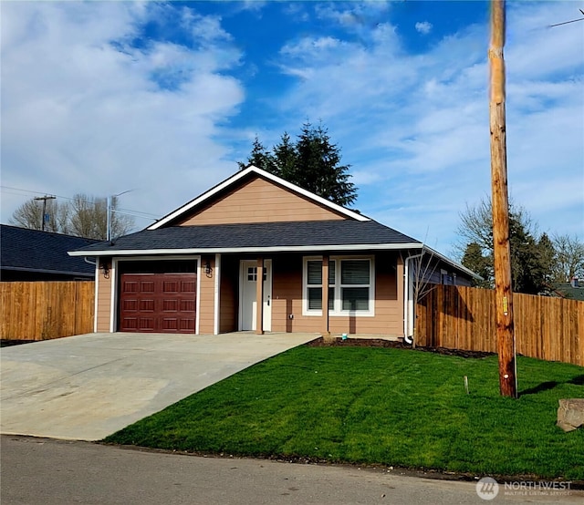 view of front facade with a garage, driveway, fence, and a front yard