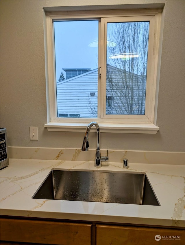 details featuring light stone counters and sink