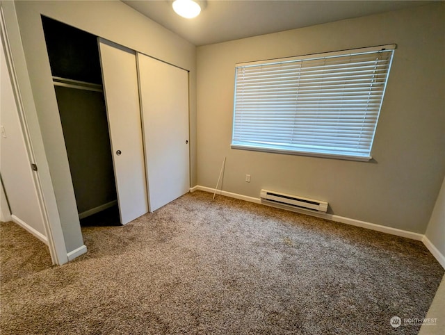 unfurnished bedroom featuring carpet flooring, a closet, and a baseboard radiator