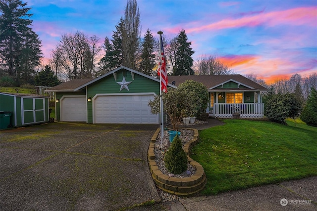 ranch-style home featuring a porch, a garage, a storage unit, and a lawn