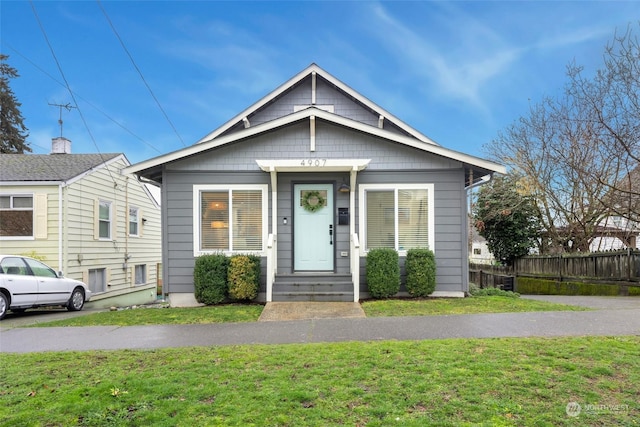 bungalow-style house featuring a front lawn