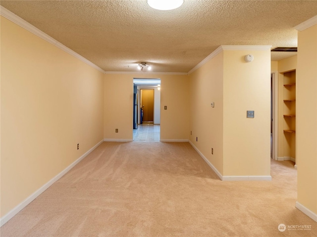 carpeted spare room featuring a textured ceiling and ornamental molding