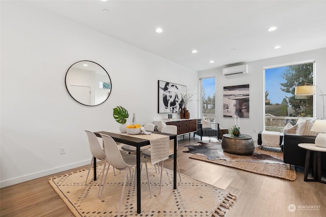 dining area featuring a wall unit AC and wood-type flooring