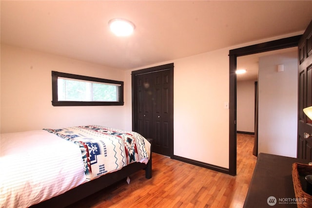 bedroom featuring light wood-type flooring, a closet, and baseboards