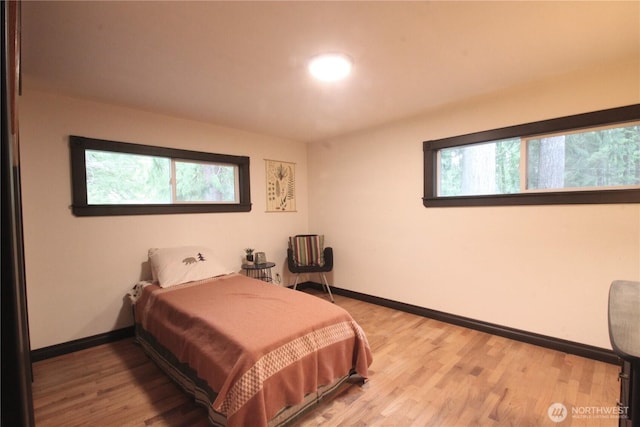 bedroom with wood finished floors and baseboards