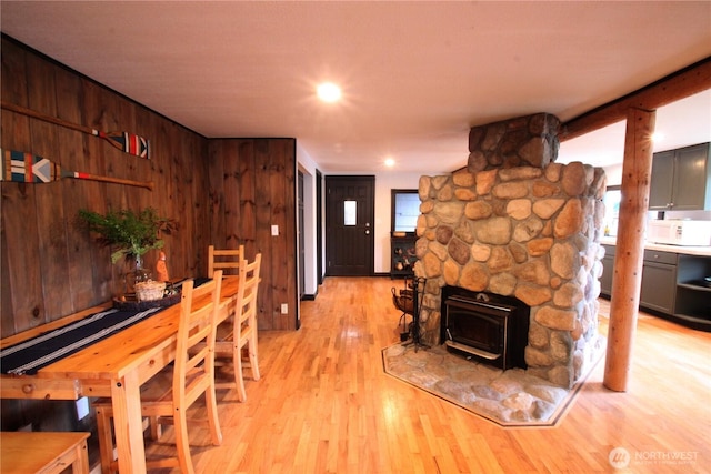 dining space featuring light wood-style floors and wooden walls