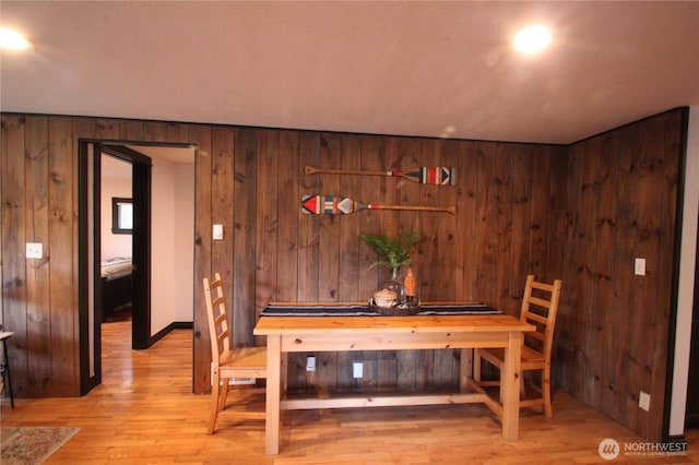 dining room with wood walls and wood finished floors