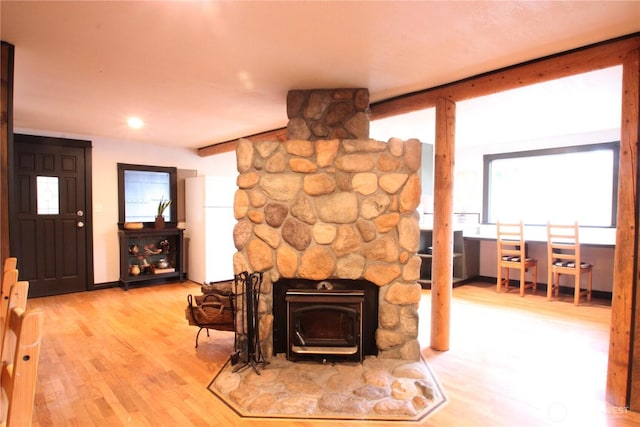 living area with a wood stove and wood finished floors