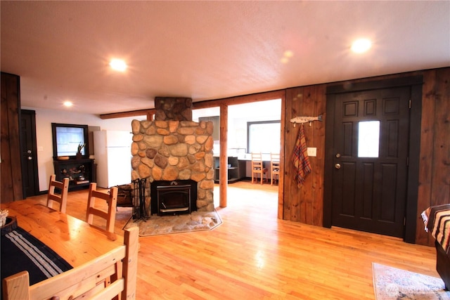 interior space with a wealth of natural light, wood finished floors, a wood stove, and recessed lighting