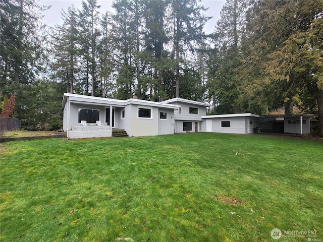 rear view of property featuring a porch and a yard