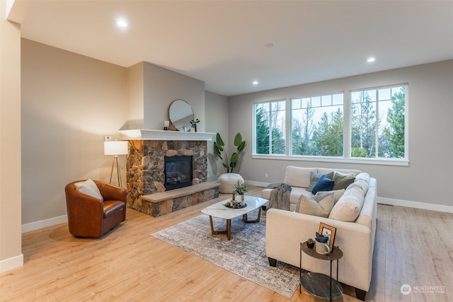 living room with a fireplace, light hardwood / wood-style flooring, and a wealth of natural light