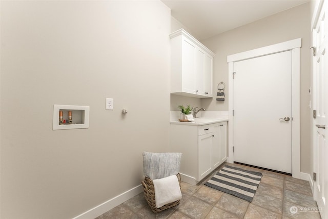 clothes washing area featuring cabinets, washer hookup, and sink