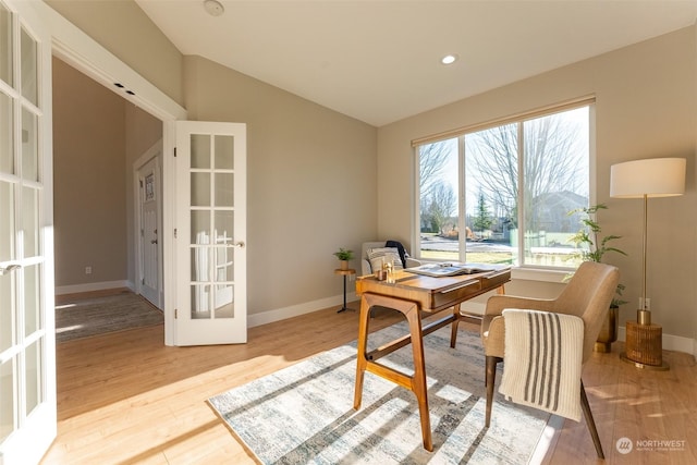 office space featuring french doors, vaulted ceiling, and light hardwood / wood-style flooring