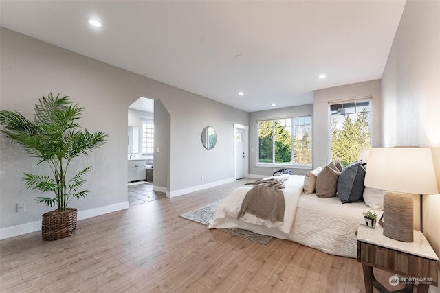 bedroom featuring light wood-type flooring and connected bathroom