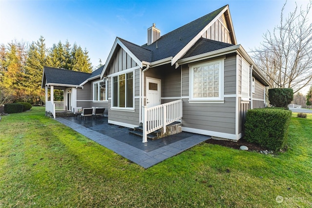 back of house with a lawn and a patio area