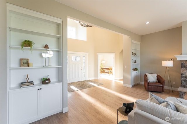 living room with built in features and light wood-type flooring