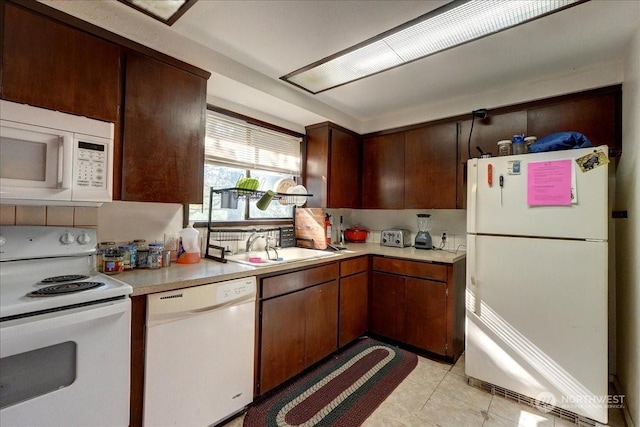 kitchen with sink, light tile patterned flooring, and white appliances