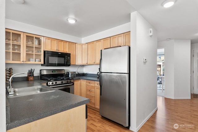 kitchen with light brown cabinets, sink, light wood-type flooring, and stainless steel appliances