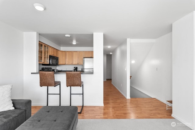 kitchen featuring light hardwood / wood-style floors, stainless steel fridge, and kitchen peninsula