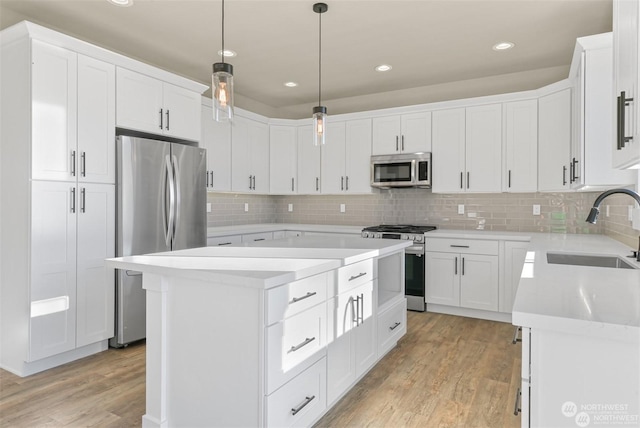 kitchen with sink, a center island, white cabinets, and appliances with stainless steel finishes