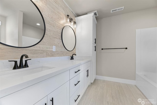 bathroom with wooden walls, vanity, and hardwood / wood-style flooring