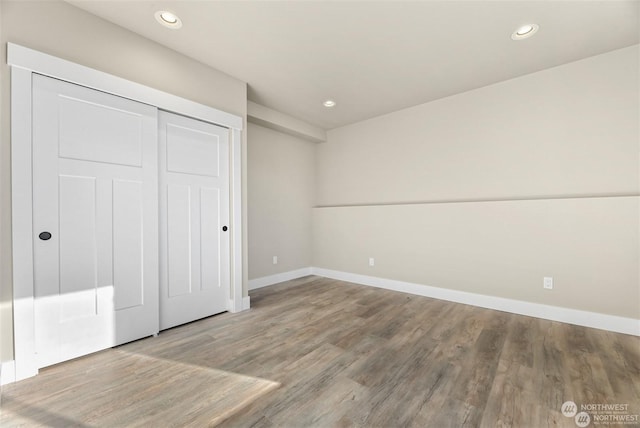 unfurnished bedroom featuring a closet and hardwood / wood-style flooring