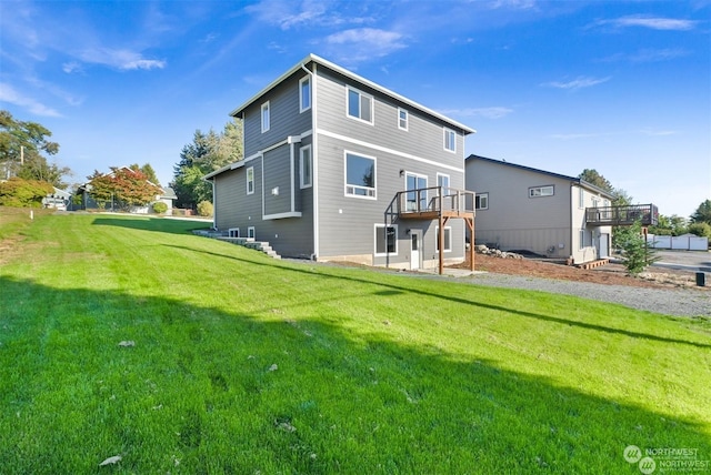 back of house with a lawn and a wooden deck