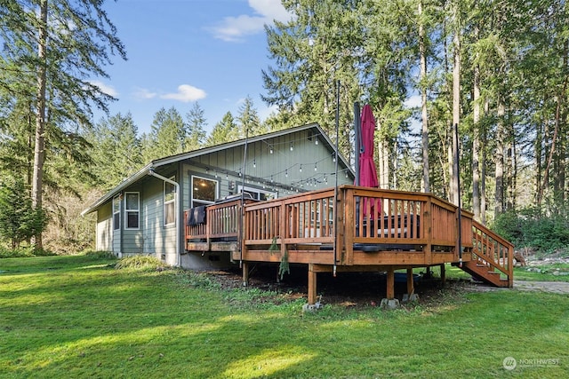 rear view of property with a yard and a deck