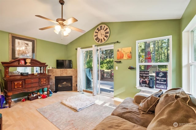 living room with ceiling fan, a fireplace, wood-type flooring, and vaulted ceiling