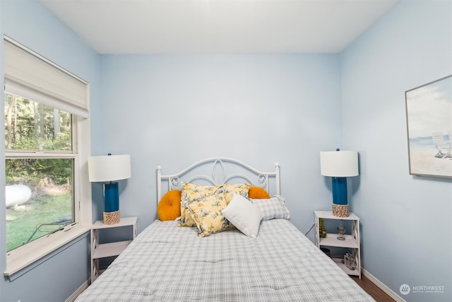 bedroom with dark hardwood / wood-style floors