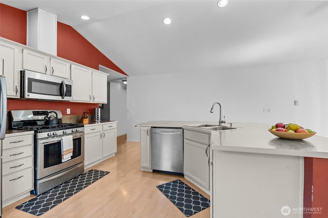 10405 Olympic Pl, Anderson Island, WA 98303 - kitchen with vaulted ceiling, appliances with stainless steel finishes, white cabinetry, and a sink