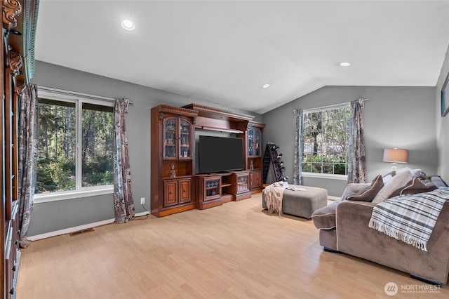 10405 Olympic Pl, Anderson Island, WA 98303 - living room with lofted ceiling, wood finished floors, visible vents, and a healthy amount of sunlight