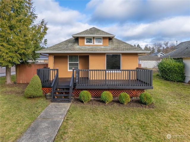 bungalow-style home featuring a wooden deck and a front yard