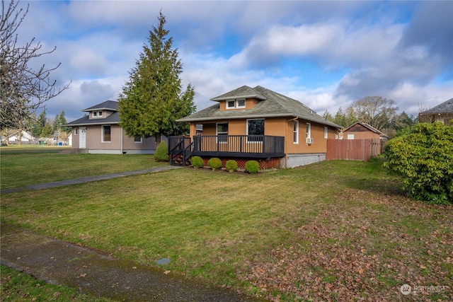 view of front facade with a wooden deck and a front lawn