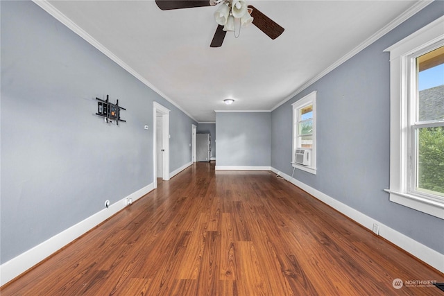 unfurnished living room featuring a wealth of natural light, crown molding, and dark wood-type flooring