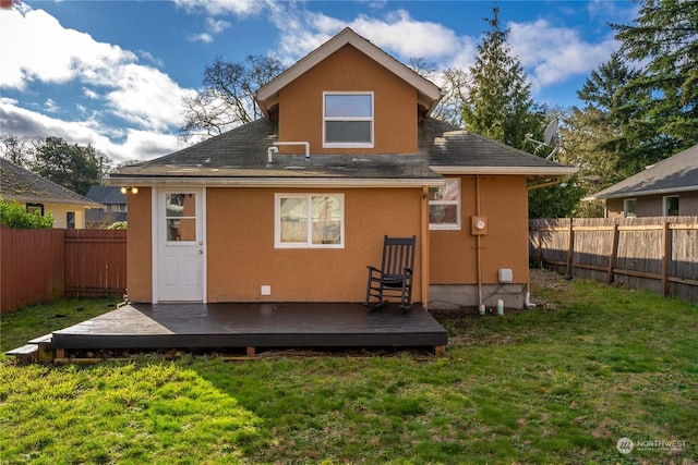 rear view of house featuring a wooden deck and a yard