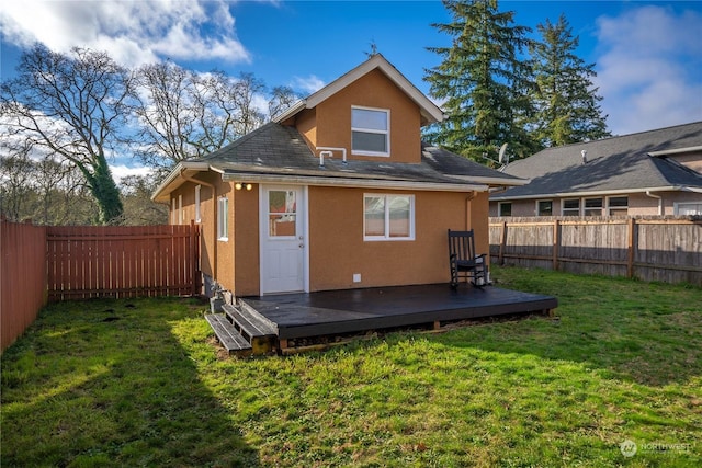 rear view of property featuring a wooden deck and a yard