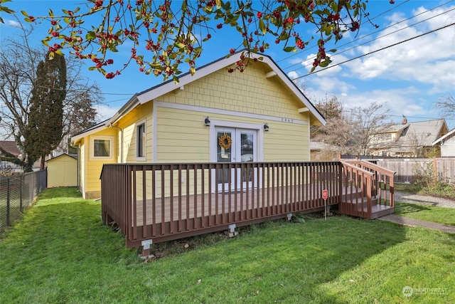 rear view of property featuring a lawn and a wooden deck