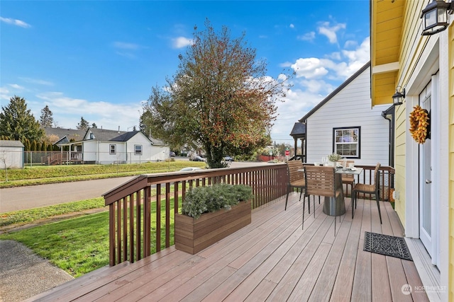 wooden deck featuring a lawn