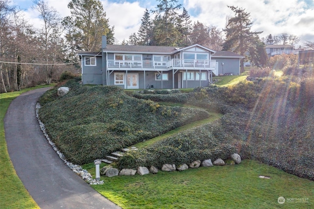 view of front facade featuring a deck and a front yard