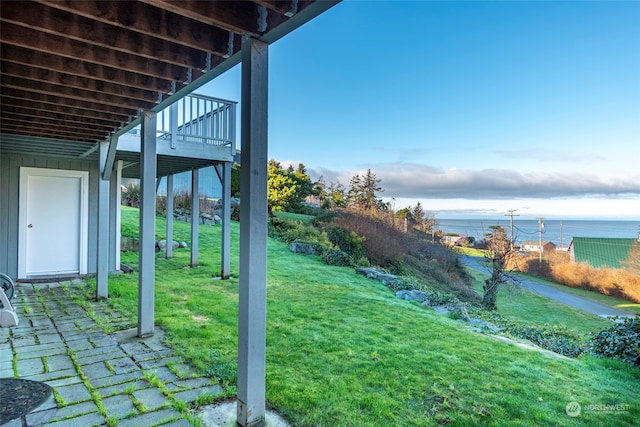 view of yard with a deck with water view