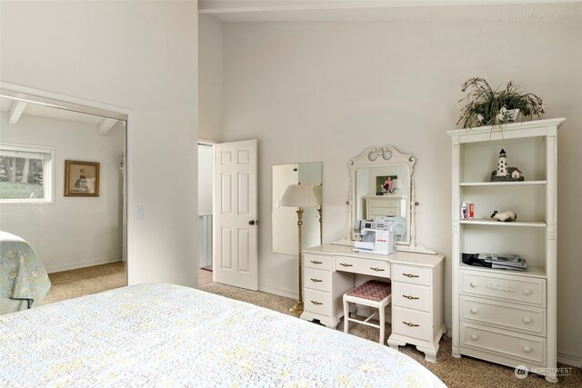 bedroom with carpet flooring, a towering ceiling, and beam ceiling