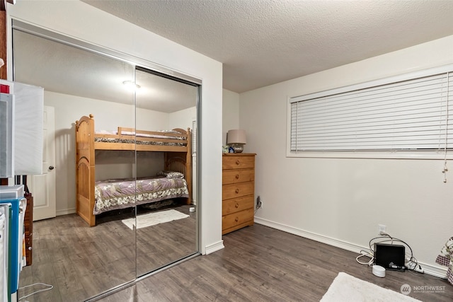 bedroom featuring a textured ceiling, dark hardwood / wood-style flooring, and a closet